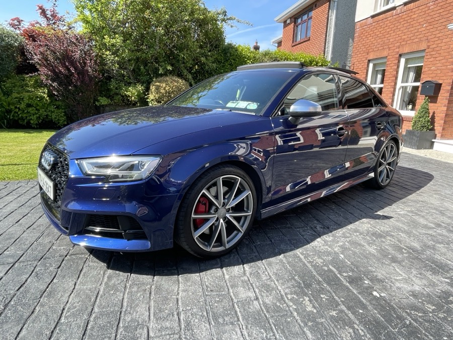 Front three-quarter view of a blue saloon on a driveway